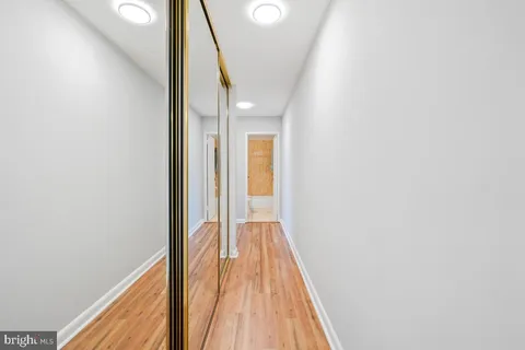 a view of a hallway with wooden floor and staircase