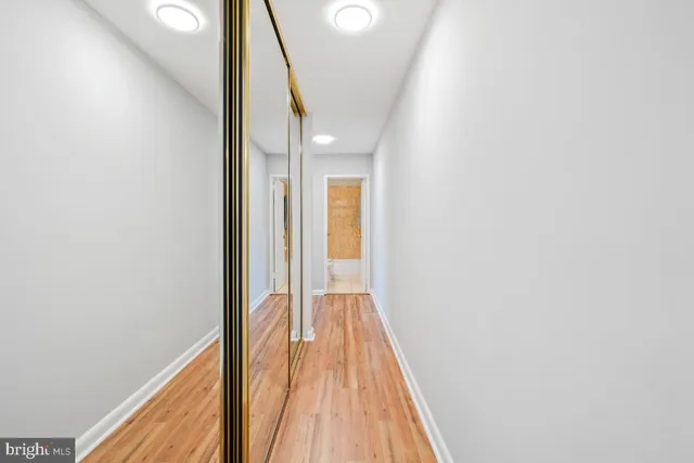 a view of a hallway with wooden floor and staircase