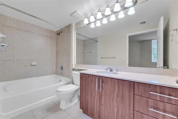 a bathroom with a tub a sink and mirror