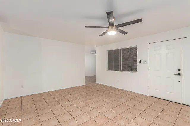 a view of an empty room with a ceiling fan and a window