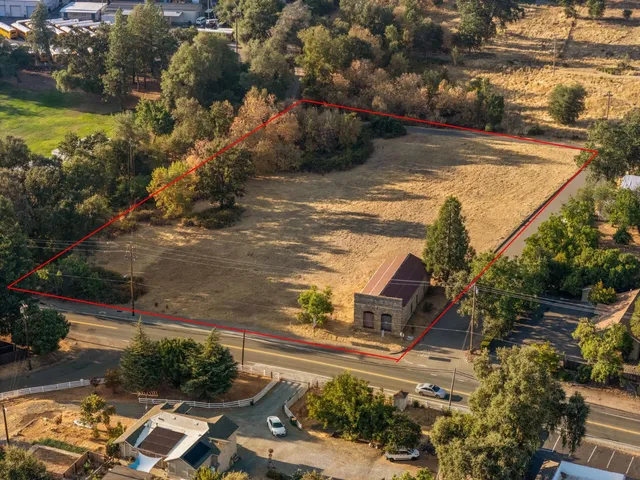 an aerial view of residential houses with outdoor space and trees