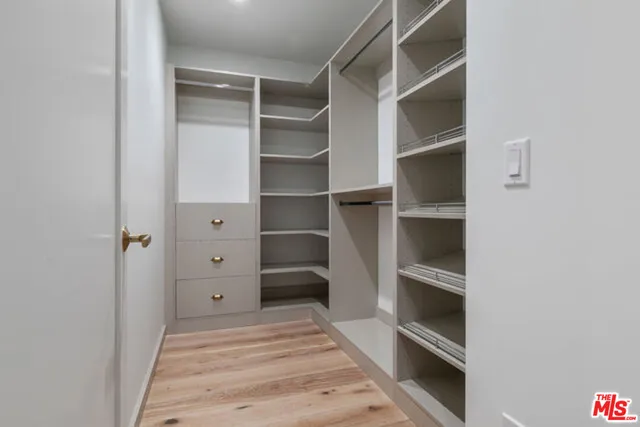 a view of walk in closet with empty racks