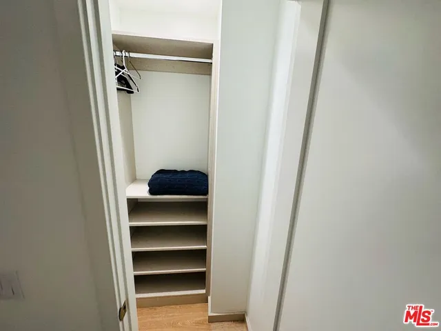 a view of walk in closet with empty racks