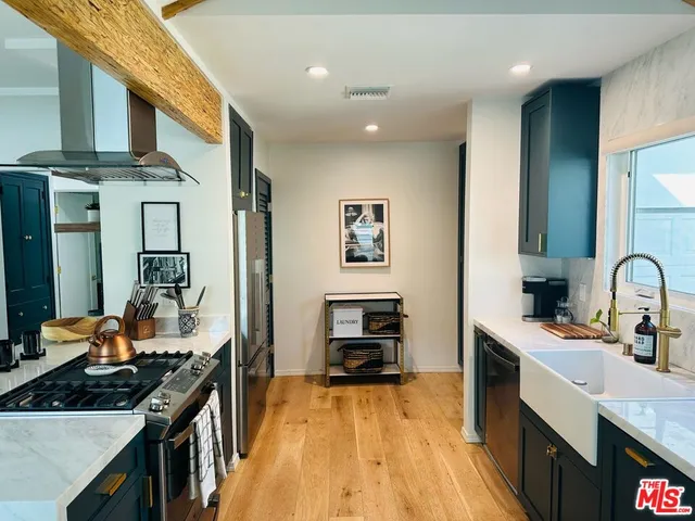 a kitchen with stainless steel appliances a sink stove and cabinets
