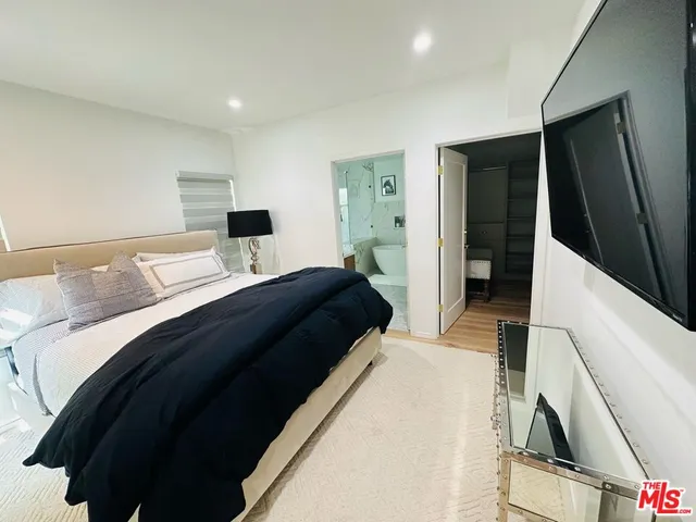 a bedroom with a bed and a flat tv screen