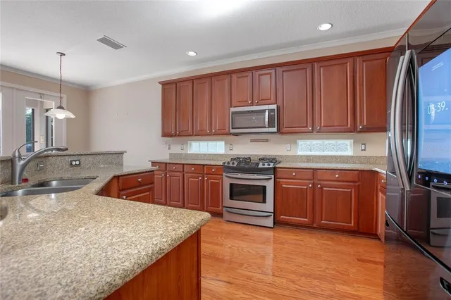 a kitchen with stainless steel appliances granite countertop a sink stove and microwave