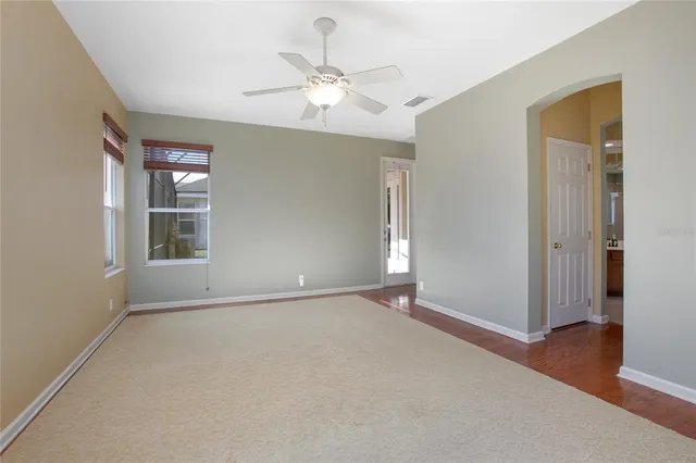 an empty room with fan and windows