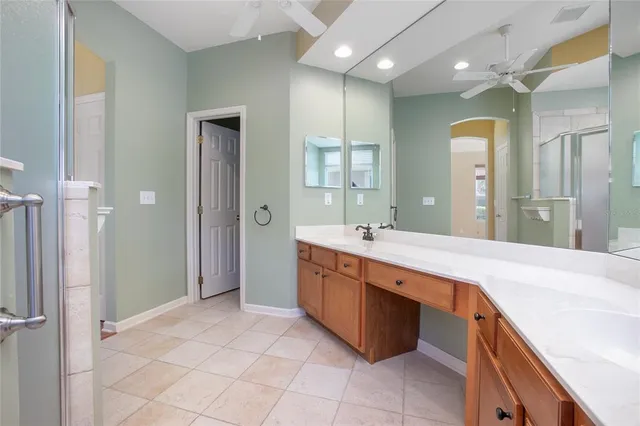 a spacious bathroom with a granite countertop sink a mirror and a shower