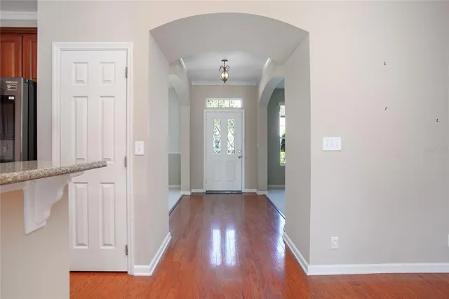 a view of a hallway with wooden floor and staircase