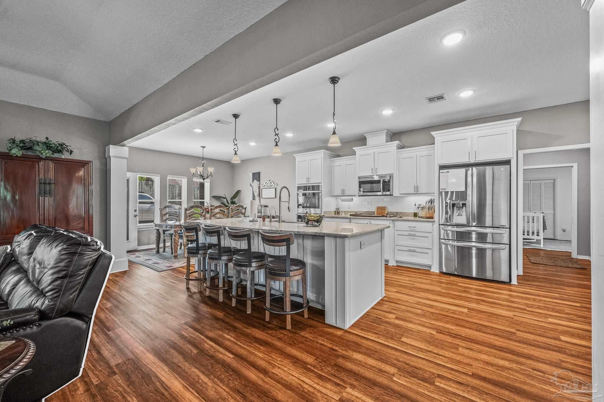 10443 Tam O Shanter Road Pensacola, FL 32514 - Photo 17 of 57 a kitchen with stainless steel appliances granite countertop a table chairs sink and cabinets