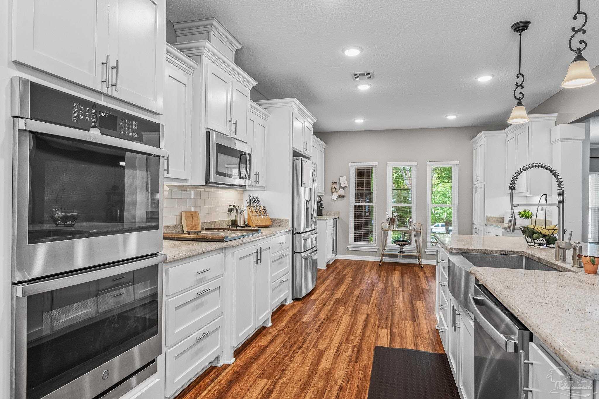 10443 Tam O Shanter Road Pensacola, FL 32514 - Photo 19 of 57 a kitchen with kitchen island granite countertop a stove a sink and a microwave
