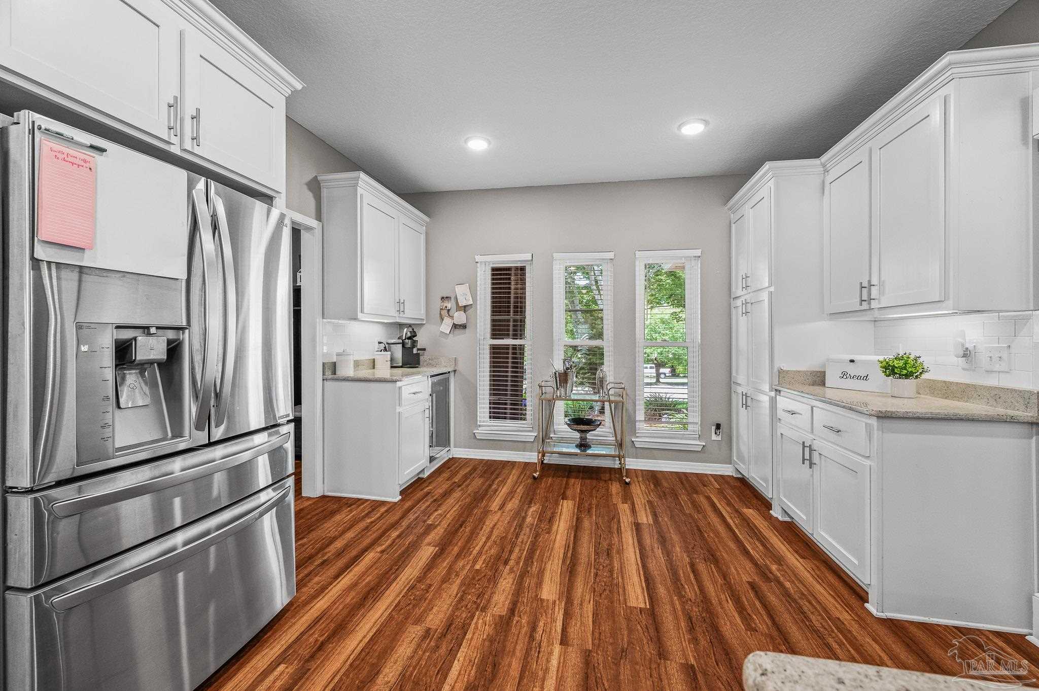 10443 Tam O Shanter Road Pensacola, FL 32514 - Photo 21 of 57 a kitchen with white cabinets and stainless steel appliances