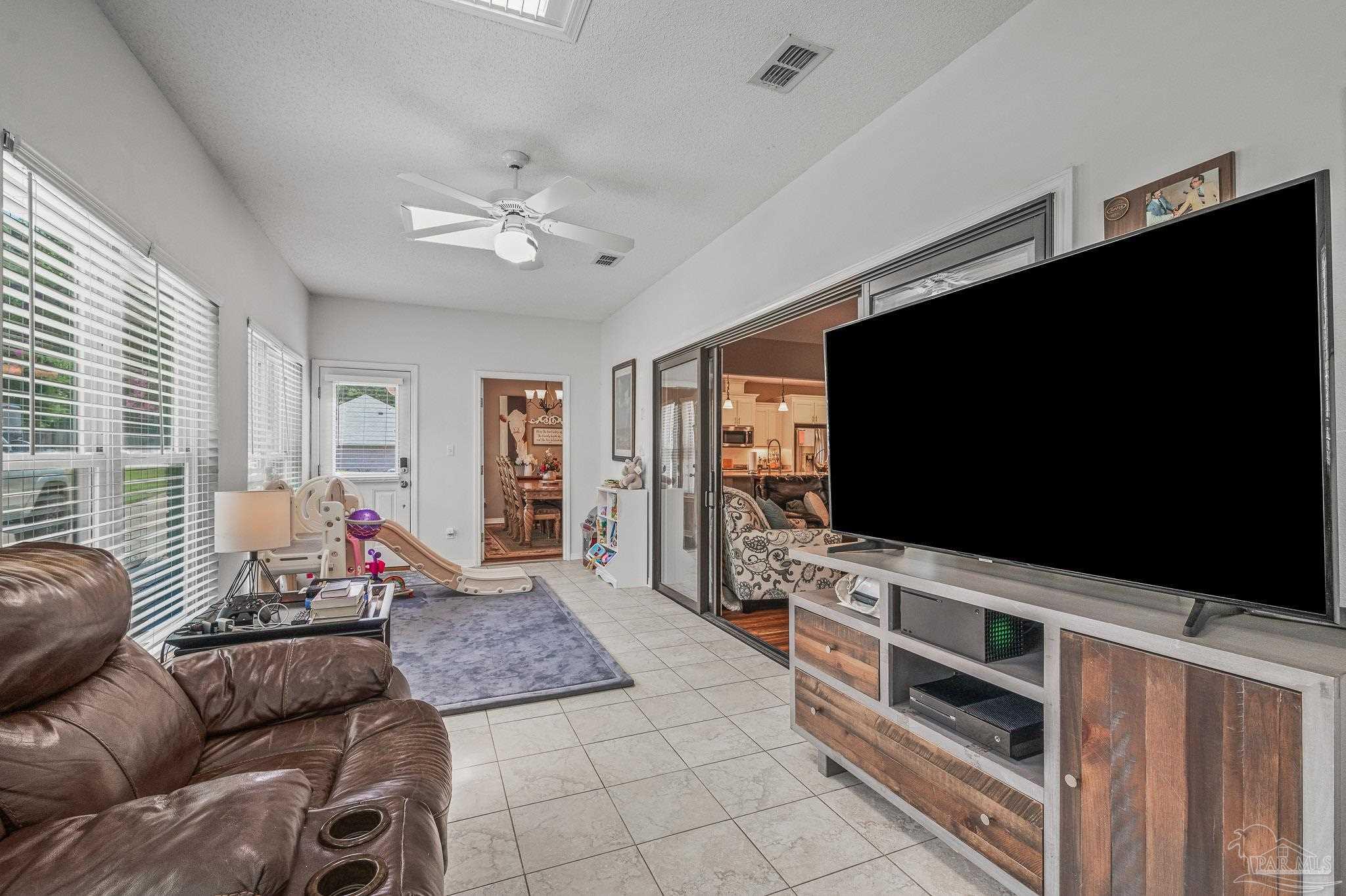 10443 Tam O Shanter Road Pensacola, FL 32514 - Photo 26 of 57 a living room with furniture and a flat screen tv