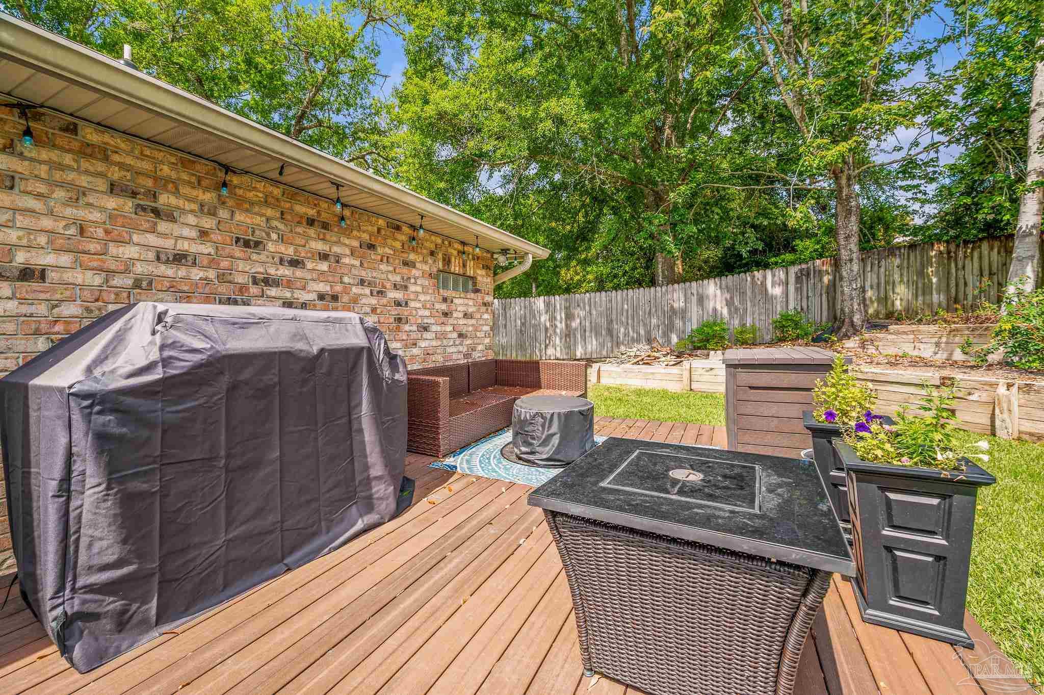 10443 Tam O Shanter Road Pensacola, FL 32514 - Photo 56 of 57 a view of a patio with table and chairs with wooden floor and fence