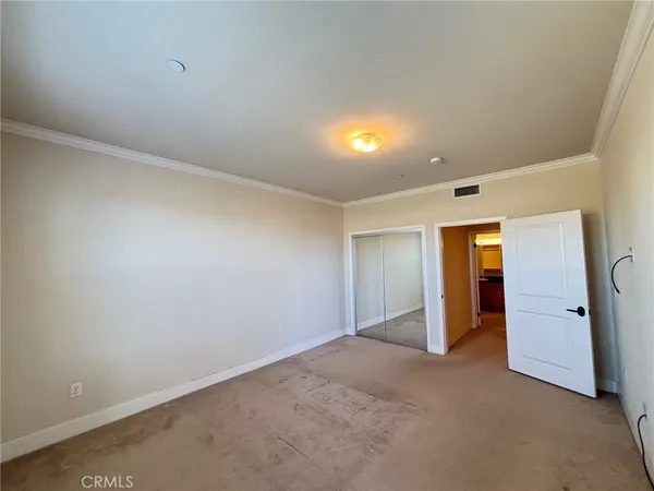 an empty room with closet and mirror