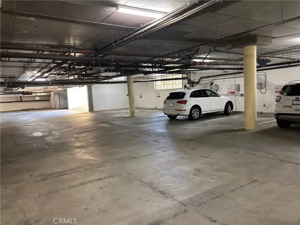 a view of parking garage with cars parked