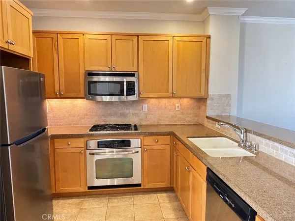 a kitchen with granite countertop a stove a sink and a microwave
