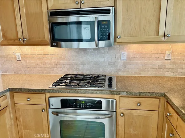 a kitchen with stove top oven and cabinets