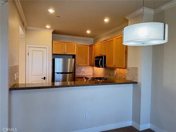 a kitchen with stainless steel appliances granite countertop a sink and a refrigerator