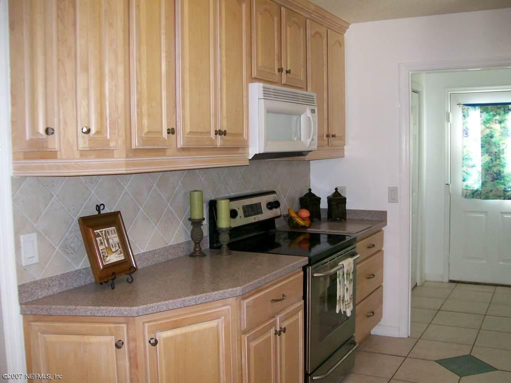 3333 Carmel Road St. Augustine, FL 32086 - Photo 11 of 12 a kitchen with stainless steel appliances granite countertop a sink a stove and a white cabinets