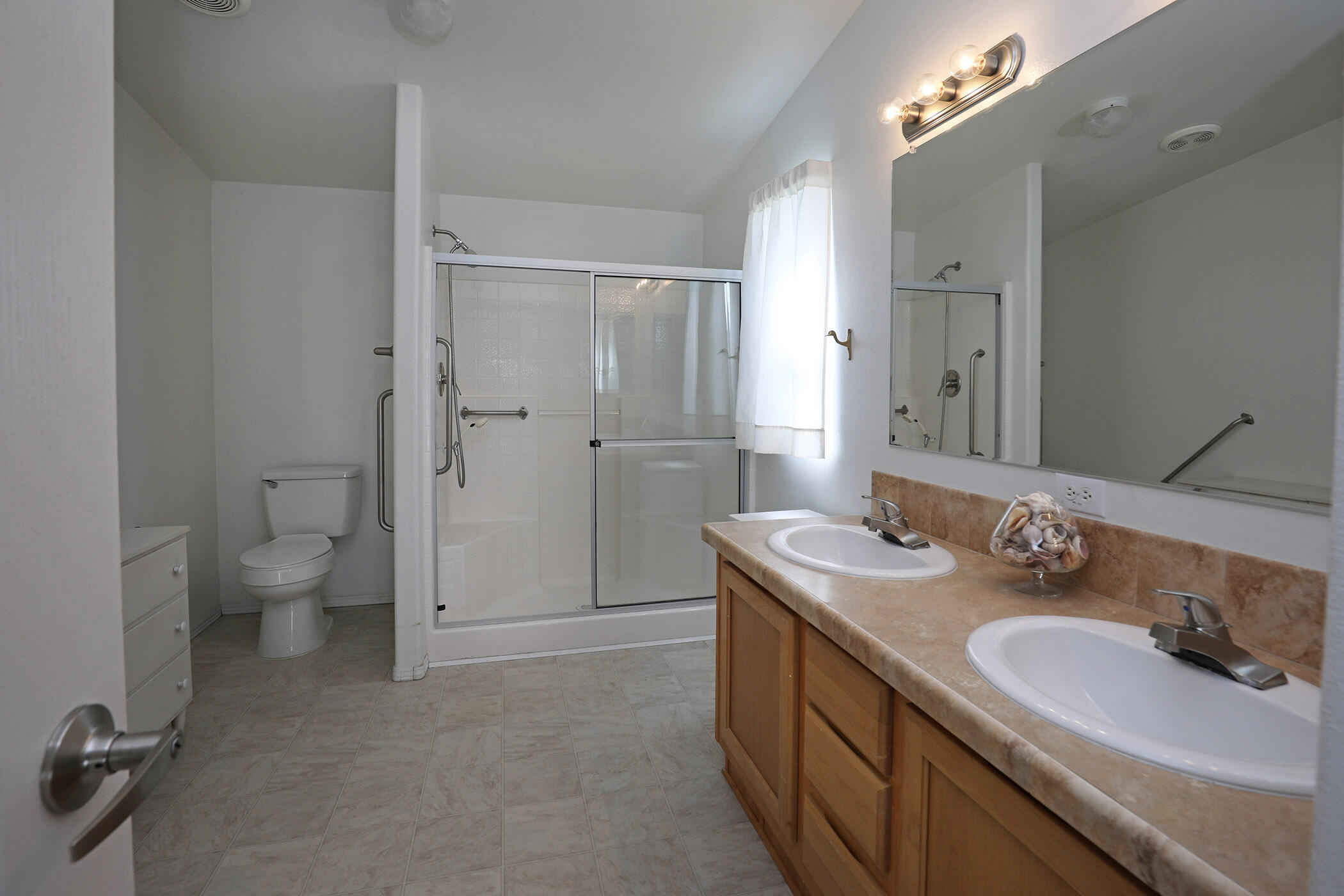 6180 Via Real, Unit 61 Carpinteria, CA 93013 - Photo 14 of 24 a spacious bathroom with a granite countertop sink a mirror and a toilet