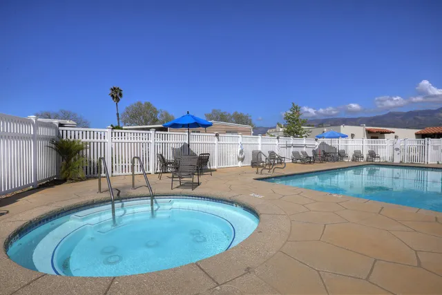 a view of a swimming pool with a patio and a yard