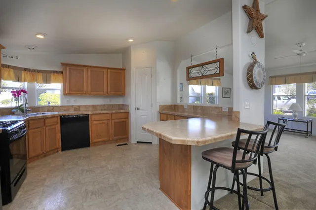 a kitchen with a stove a sink a window and dining table
