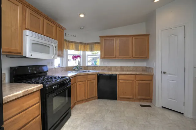 a kitchen with stainless steel appliances granite countertop a stove sink and cabinets