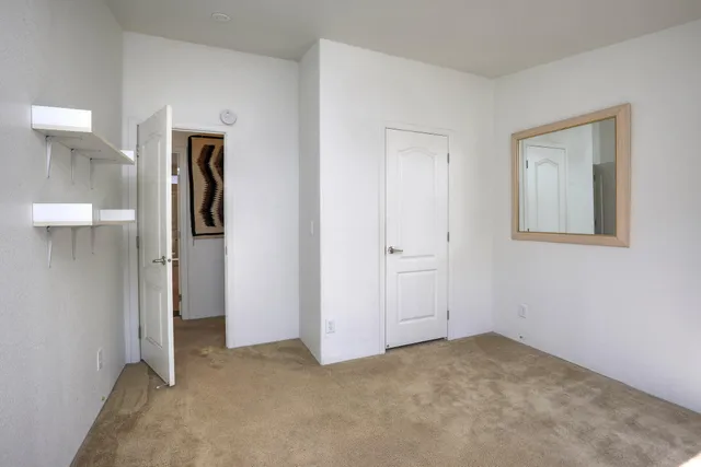 an empty room with closet and a bathroom