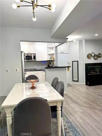 a kitchen with a table chairs refrigerator and cabinets