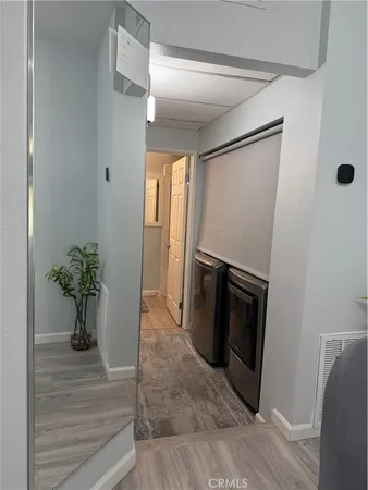 a view of a hallway with wooden floor and a potted plant