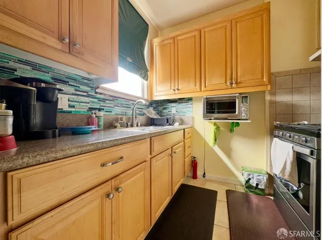 a kitchen with stainless steel appliances granite countertop a sink a stove and cabinets