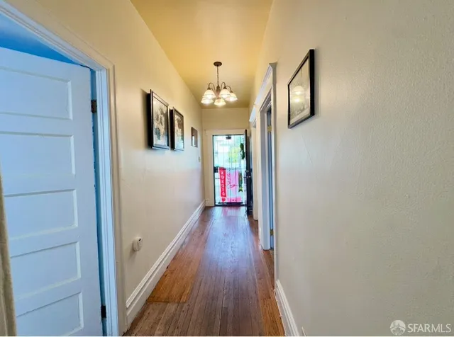 a view of a hallway with wooden floor and staircase