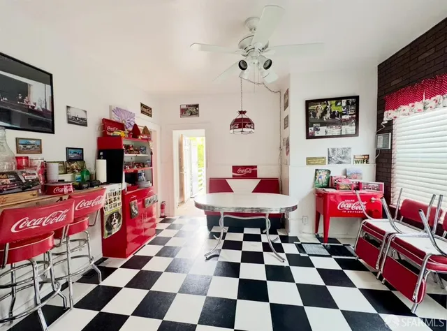 a living room with a black white checkered floor with many windows
