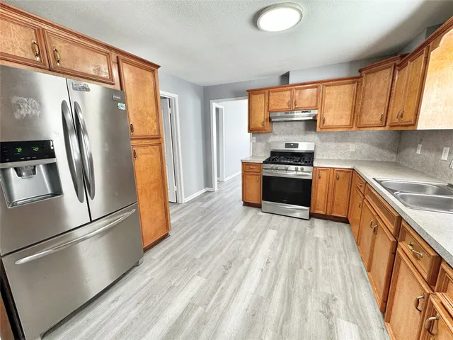 a kitchen with stainless steel appliances a refrigerator sink and microwave