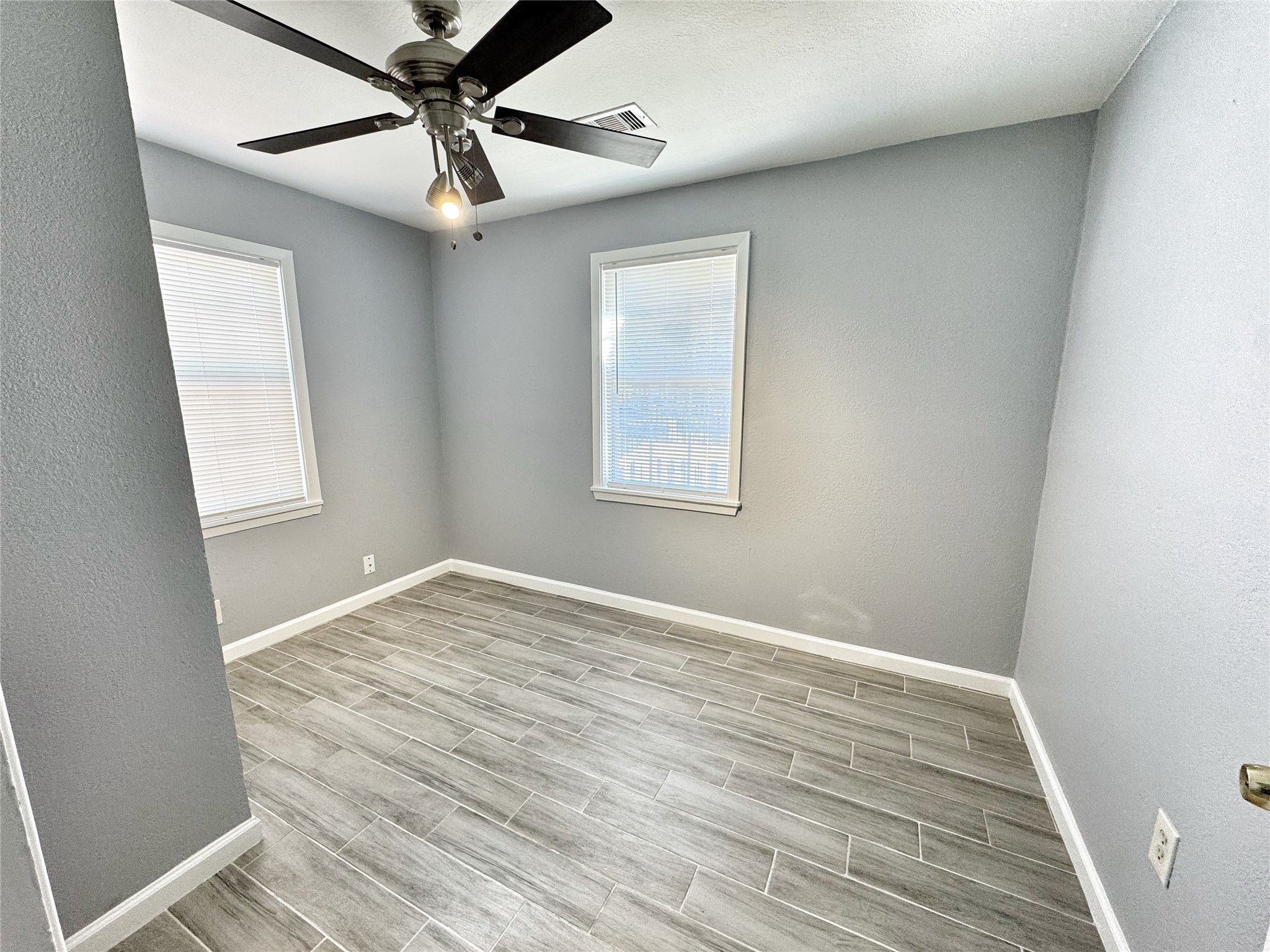 2633 Hollis Street Houston, TX 77093 - Photo 17 of 32 an empty room with wooden floor fan and windows