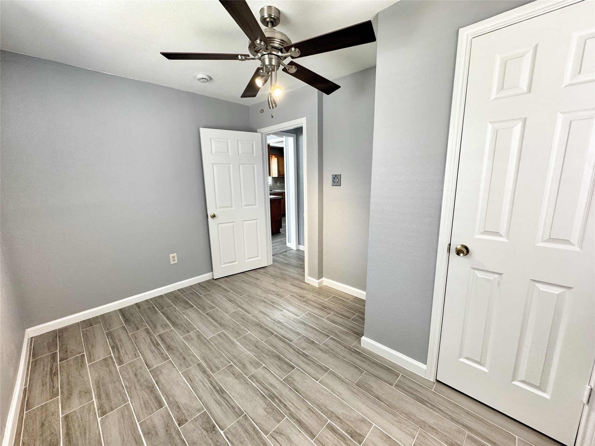 2633 Hollis Street Houston, TX 77093 - Photo 18 of 32 a view of an empty room with wooden floor and a ceiling fan
