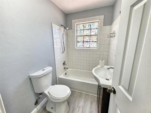 a white toilet sitting next to a bath tub