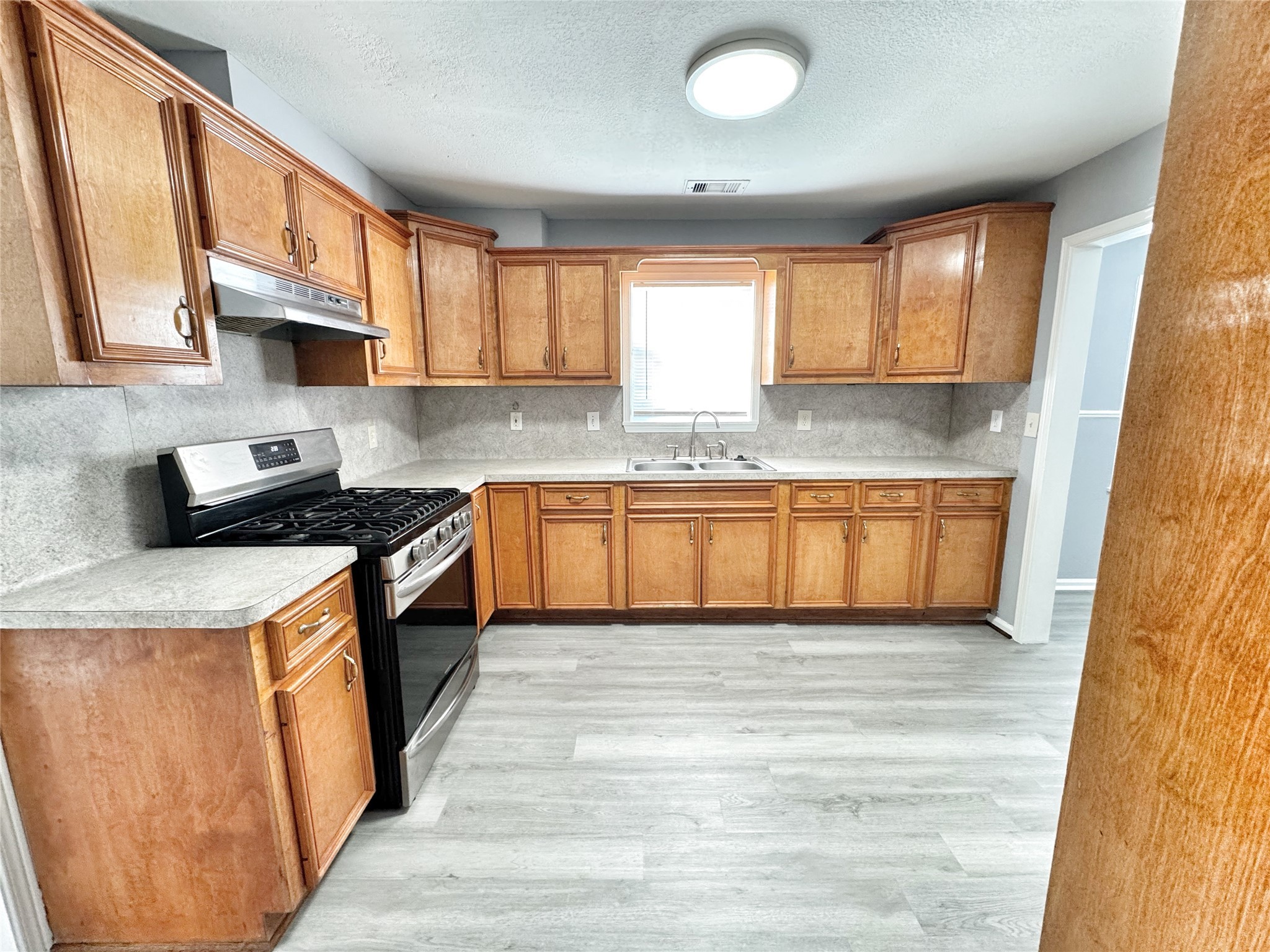 2633 Hollis Street Houston, TX 77093 - Photo 8 of 32 a kitchen with stainless steel appliances granite countertop a stove a sink and a refrigerator