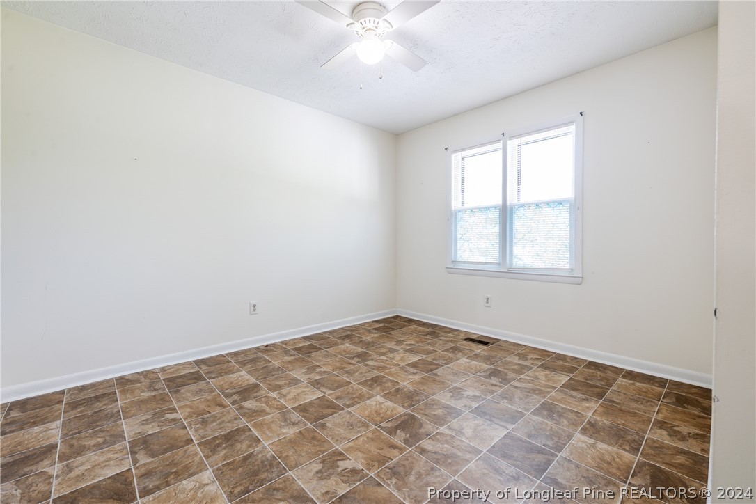 101 Dundee Lane Spring Lake, NC 28390 - Photo 14 of 32 an empty room with a chandelier fan and windows
