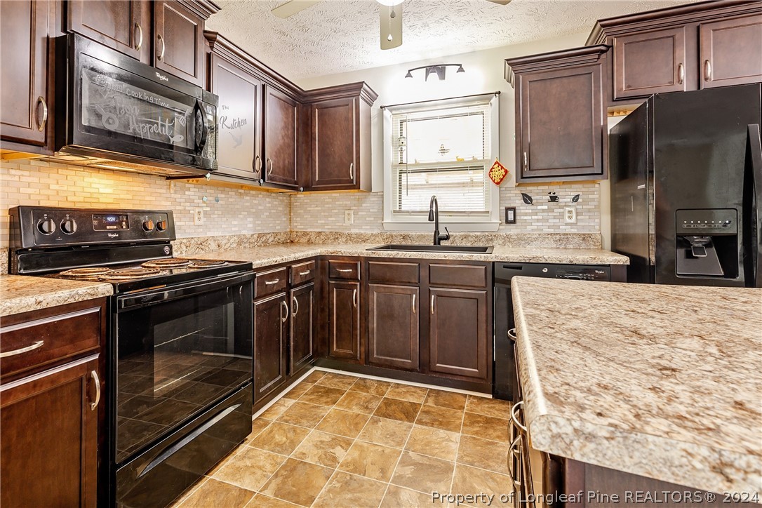 101 Dundee Lane Spring Lake, NC 28390 - Photo 7 of 32 a kitchen with stainless steel appliances granite countertop a stove microwave and sink