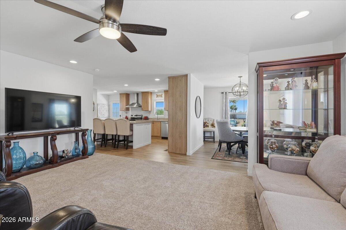 320 East McKellips Road, Unit 199 Mesa, AZ 85201 - Photo 11 of 32 a living room with furniture and a flat screen tv with kitchen view