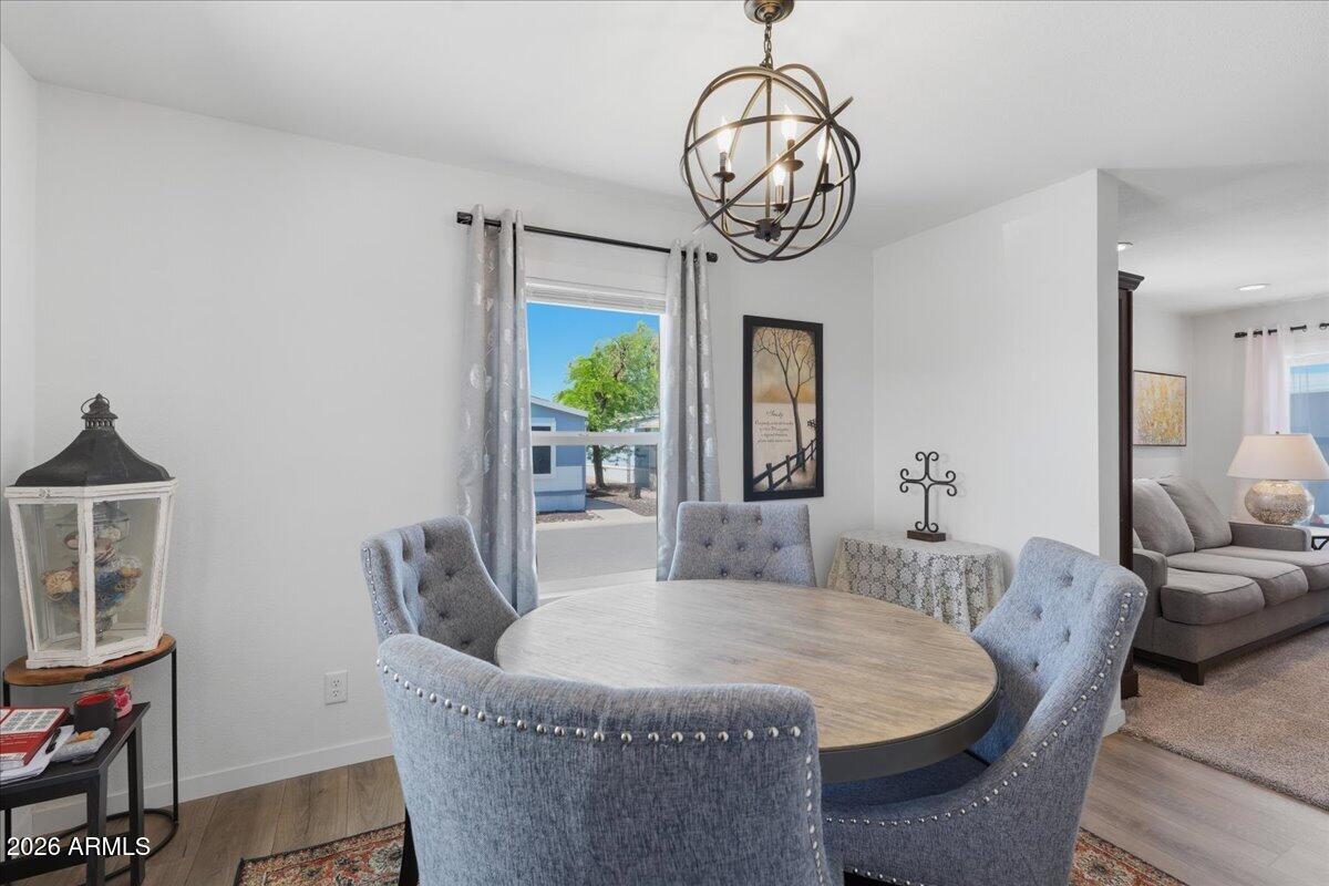 320 East McKellips Road, Unit 199 Mesa, AZ 85201 - Photo 18 of 32 a dining room with furniture a chandelier and wooden floor