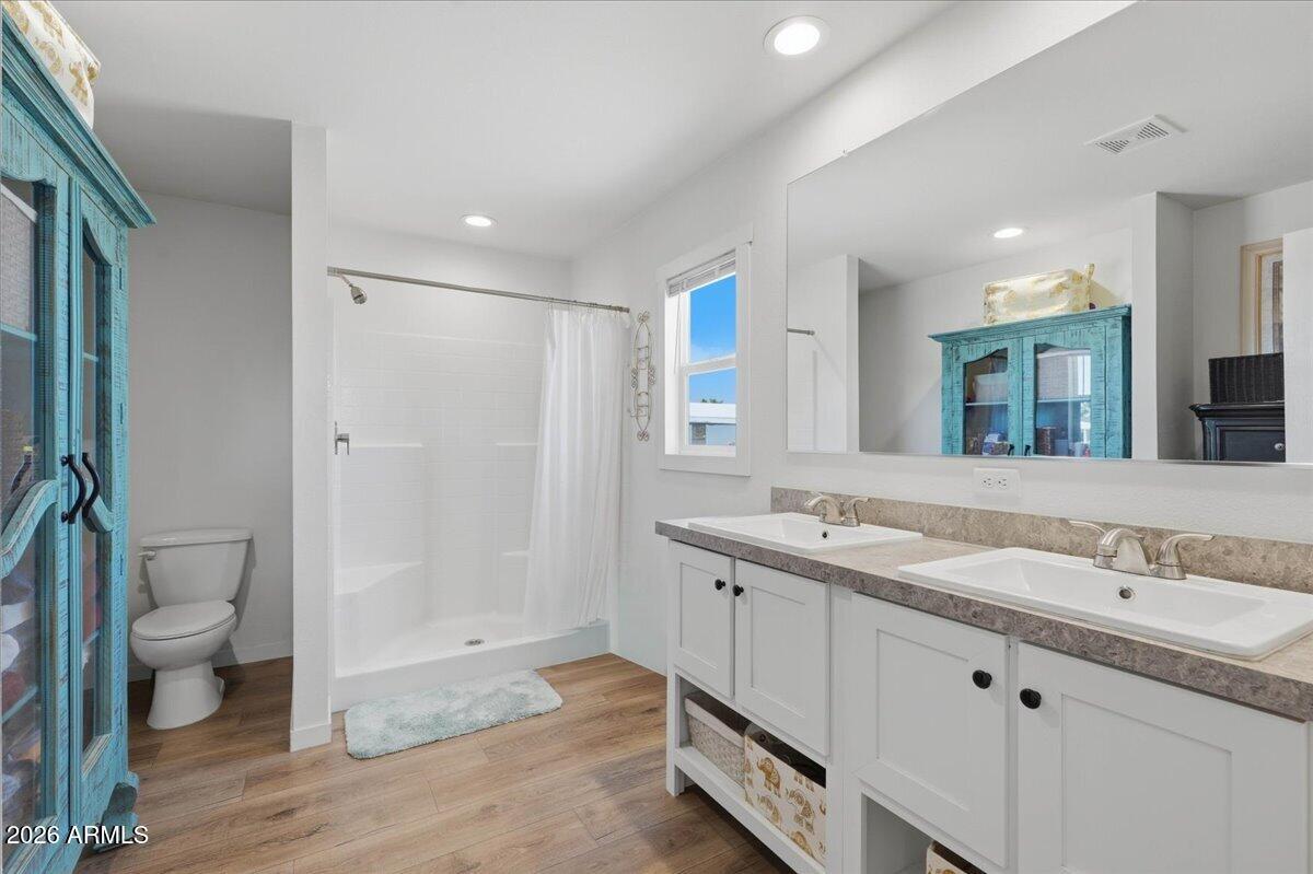 320 East McKellips Road, Unit 199 Mesa, AZ 85201 - Photo 22 of 32 a bathroom with a granite countertop sink a toilet a shower and a mirror