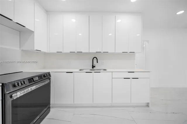 a kitchen with white cabinets and stainless steel appliances