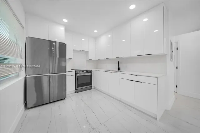 a kitchen with white cabinets and stainless steel appliances