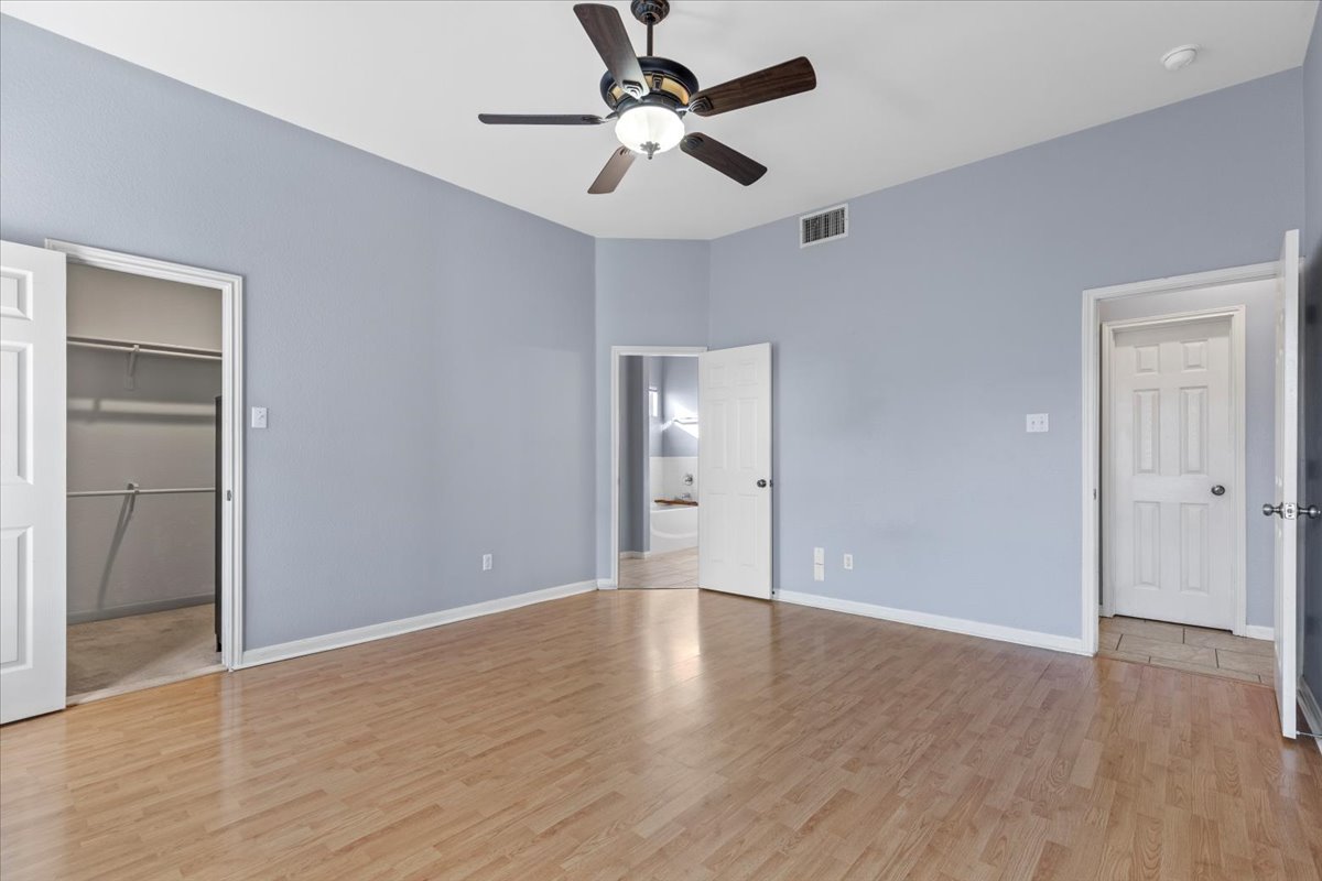 3523 Cheyenne Street Round Rock, TX 78665 - Photo 13 of 34 Unfurnished bedroom featuring a walk in closet, light wood-type flooring, and ceiling fan