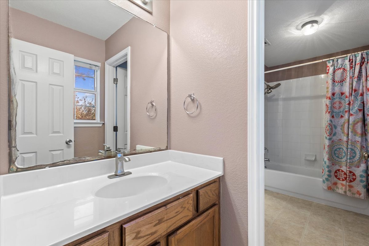 3523 Cheyenne Street Round Rock, TX 78665 - Photo 20 of 34 Full bathroom with shower / bath combo with shower curtain, a textured wall, and vanity