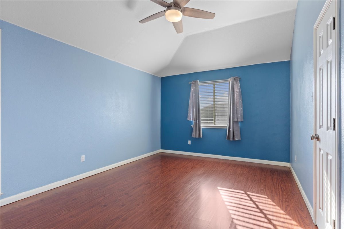 3523 Cheyenne Street Round Rock, TX 78665 - Photo 25 of 34 Unfurnished room featuring wood finished floors, lofted ceiling, and ceiling fan