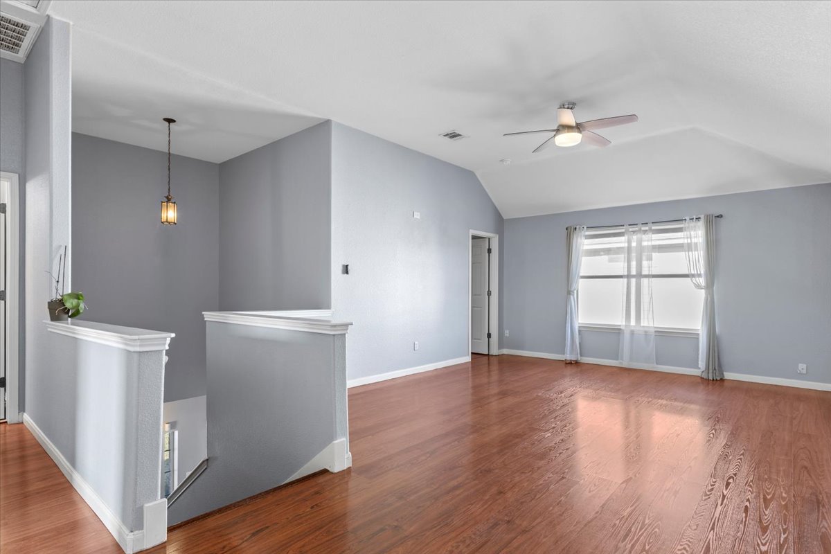 3523 Cheyenne Street Round Rock, TX 78665 - Photo 26 of 34 Unfurnished room featuring wood finished floors, a ceiling fan, and vaulted ceiling